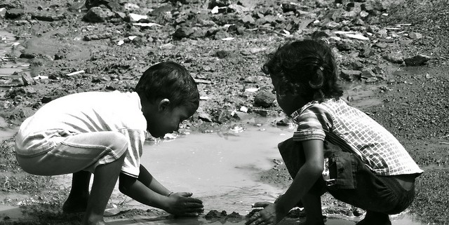 Two young children playing in the creek