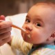 Young baby boy being fed with a spoon