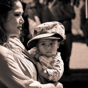 Mother holding her child wearing defence force outfit